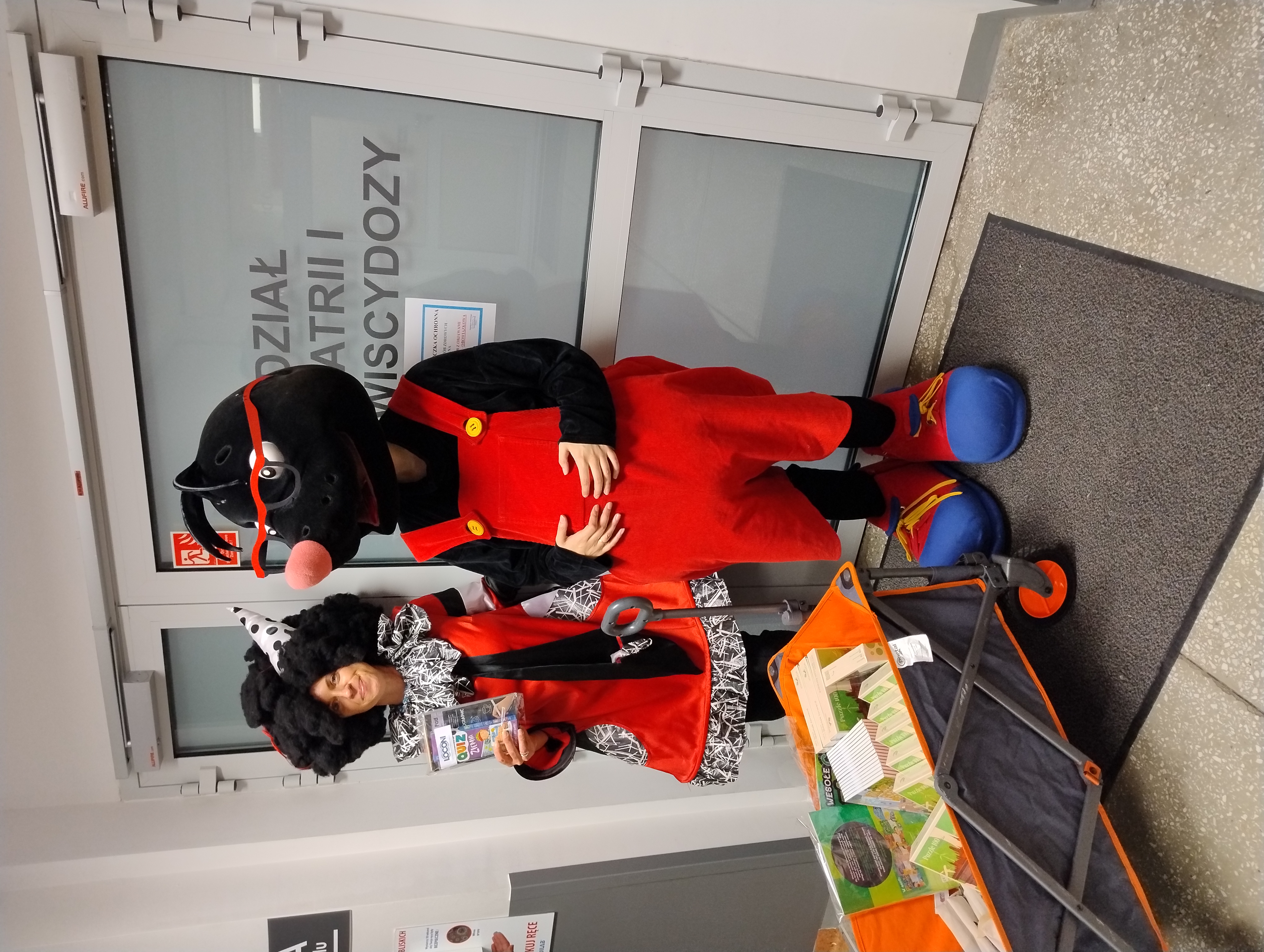 Ludzie przebrani za dwie maskotki na tle drzwi do oddziału szpitala img_20241023_125913374.jpg
